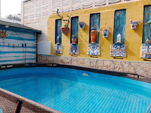 - une piscine avec des vases sur le côté du bâtiment dans l'établissement White villa few steps from most amazing beaches in Denia, swimming pool,parking, à Dénia
