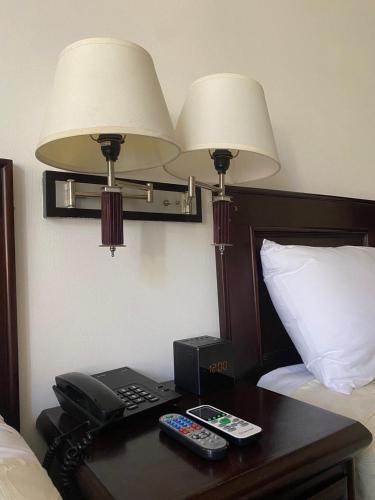 a hotel room with a desk with a phone and two lamps at Nacazcol - Playas del Coco in Coco