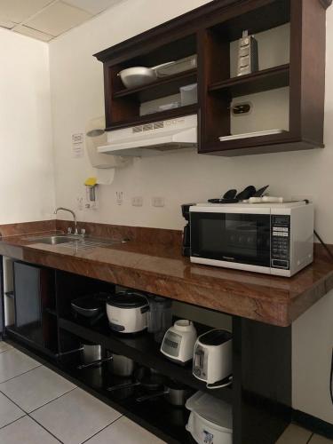 a kitchen counter with a microwave and a sink at Nacazcol - Playas del Coco in Coco