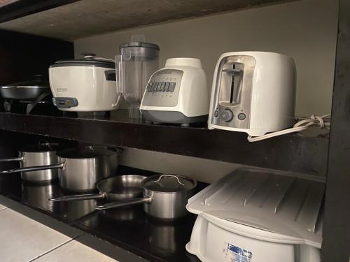 a kitchen counter with pots and pans and a coffee maker at Nacazcol - Playas del Coco in Coco