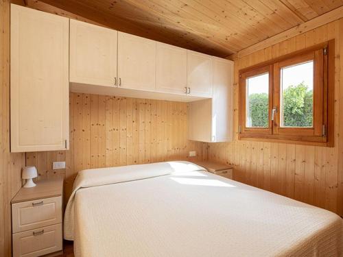 1 dormitorio con cama blanca y ventana en Camping Fano, en Fano