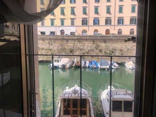 a window with a view of a marina with boats in the water at Casa Medicea sul canale in Livorno