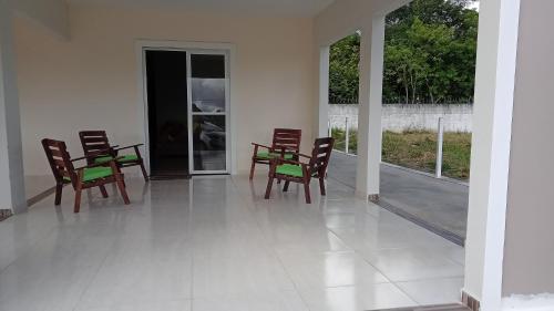 a patio with chairs and a table on a porch at Casa espaçosa churrasqueira Wi-Fi há 2km do centro in Bananeiras