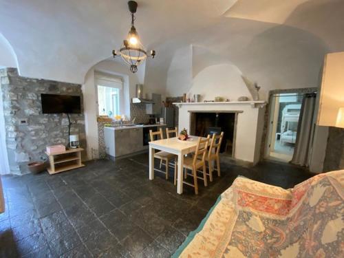 eine Küche und ein Wohnzimmer mit einem Tisch und einem Kamin in der Unterkunft Casa Caterina in Lezzeno
