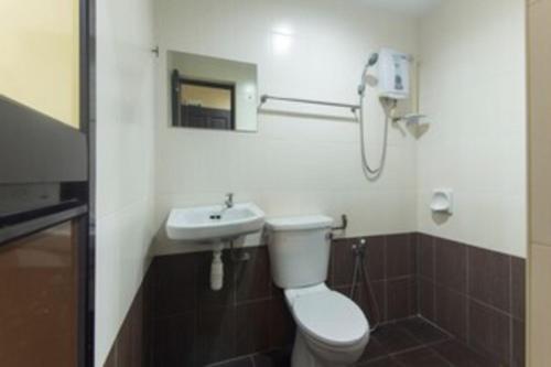 a bathroom with a toilet and a sink at Ferringhi Inn Hotel in Batu Ferringhi