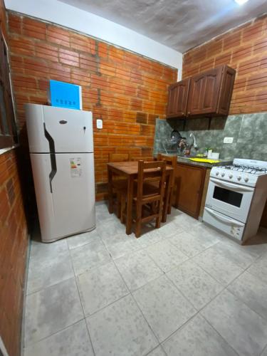 a kitchen with a white refrigerator and a table at Departamento temporario ROSARIO in Formosa