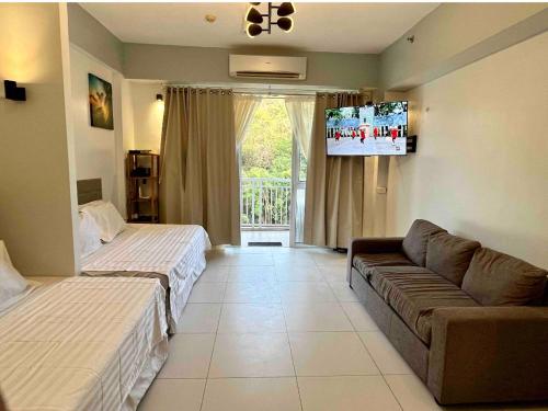 ein Hotelzimmer mit 2 Betten und einem Sofa in der Unterkunft Pico de Loro Miranda Family Beach Condo max 6 pax with fiber internet in Nasugbu