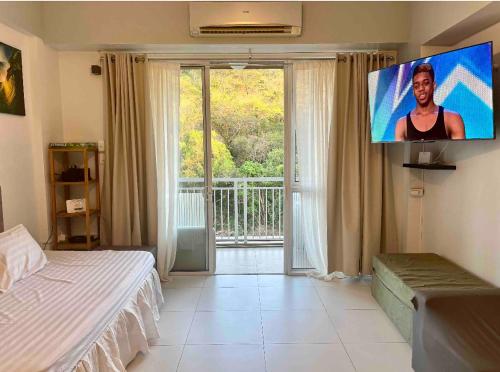 a bedroom with a bed and a flat screen tv at Pico de Loro Miranda Family Beach Condo max 6 pax with fiber internet in Nasugbu
