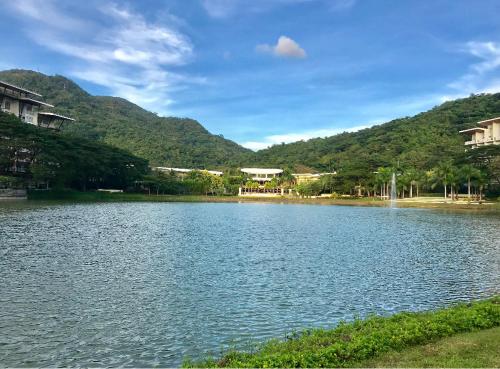 a lake with houses and mountains in the background at Pico de Loro Miranda Family Beach Condo max 6 pax with fiber internet in Nasugbu