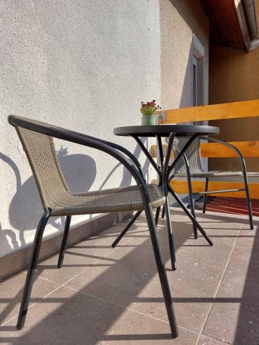 a black table and chair next to a bench at Apartman Krinka in Vrnjačka Banja