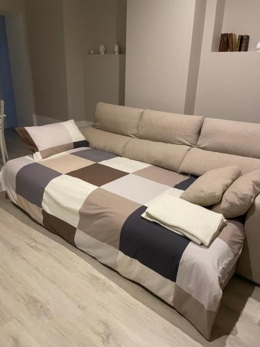un ampio letto accanto a un divano di Dieci passi dal mare e dal centro a Pescara