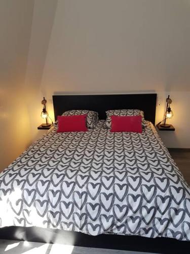une chambre avec un grand lit avec deux oreillers rouges dans l'établissement Les Embruns - Les plages - appartement 3eme étage, à Deauville