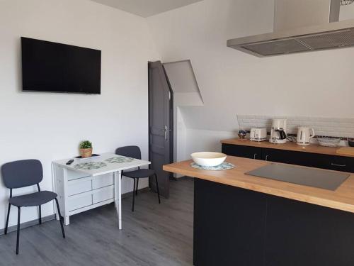- une cuisine avec une table, des chaises et un comptoir dans l'établissement Les Embruns - Les plages - appartement 3eme étage, à Deauville