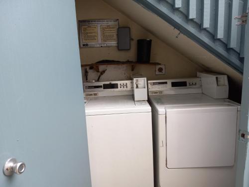 a laundry room with two machines and a staircase at SHARED TOWNHOUSE in MISSION BEACH in San Diego