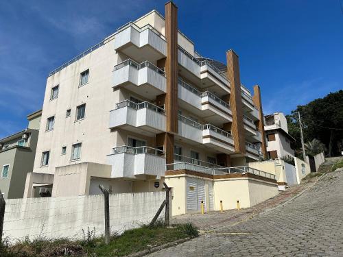 un gran edificio con balcones en un lateral en Res. Praia DI Capri, en Bombinhas