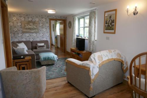 a living room with a couch and a tv at The Old Stables @ Linden Cottage in Goring