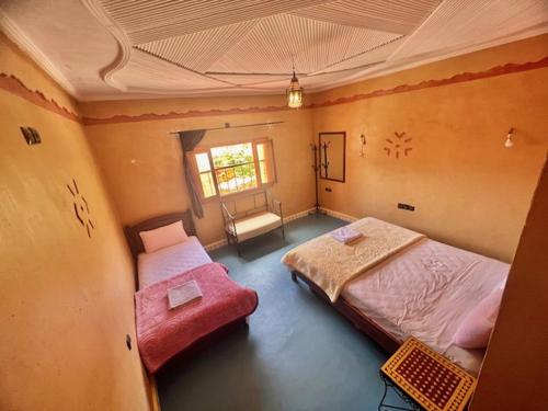 Aït Bahaにあるリヤド ラ フルールのベッドルーム1室(ベッド2台、窓付)