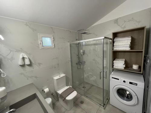 uma casa de banho com um chuveiro e uma máquina de lavar roupa em Acrocorinth Apartments em Kórinthos