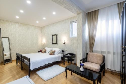 una habitación de hotel con una cama y una silla en Q&B Boutique House, en Tiflis