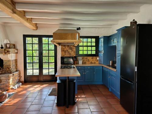 - une cuisine avec des placards bleus et une cuisinière dans l'établissement Villa Yéyéyette spacieuse 6 à 8 personnes, à Andernos-les-Bains