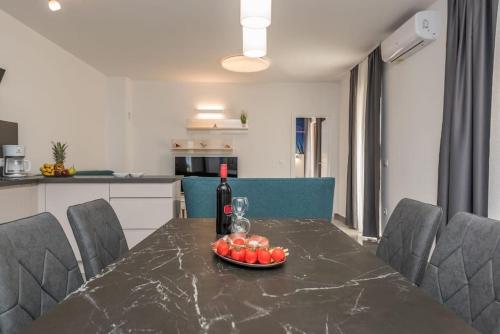 a table with a bottle of wine and a plate of fruit at Villa Mattina, with heated pool and jacuzzi in Privlaka
