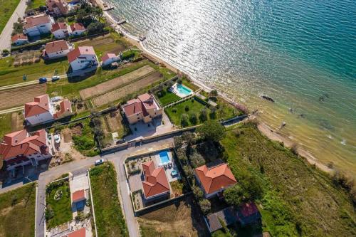 an aerial view of a house next to the water at Villa Mattina, with heated pool and jacuzzi in Privlaka