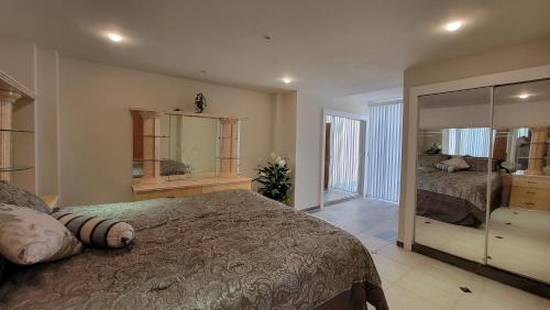 ティファナにあるOceanfront Condominiums with Private Beach Accessのベッド2台と大きな鏡のある寝室