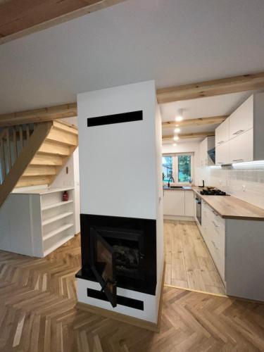 a living room with a fireplace in the middle at Domek góralski in Borki