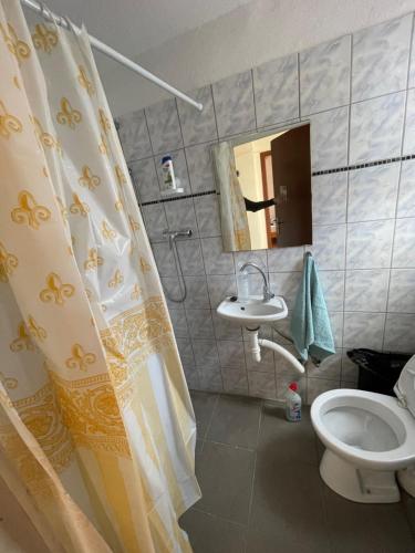 ein Bad mit einem Duschvorhang und einem WC in der Unterkunft Bollgarten 8 in Köln