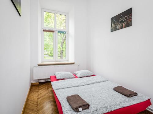 een slaapkamer met 2 bedden en een raam bij Wąsik in Krakau