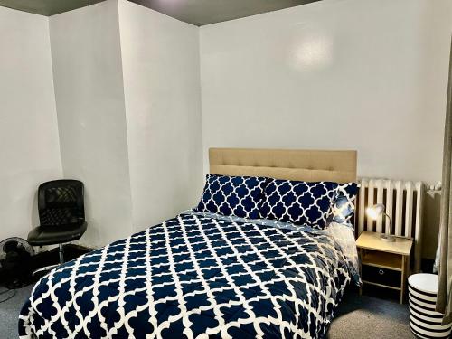 Un dormitorio con una cama azul y blanca y una silla en 3 Bedrooms, Boardwalk Duplex Beachblock Home! en Atlantic City