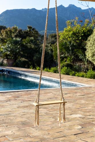 a swing in front of a swimming pool at Domaine du Reginu in Santa-Reparata-di-Balagna