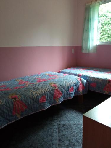 a bedroom with two beds and a window at Cabañas La Perla in Golondrinas