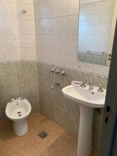 La salle de bains est pourvue d'un lavabo, de toilettes et d'un miroir. dans l'établissement Alquilo Departamento por día, à Barrio Rivadavia