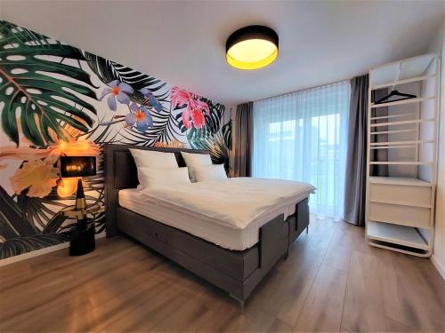 a bedroom with a large bed with a tropical mural at Blumen(t)raum Ferienwohnung 2 in Karlsruhe