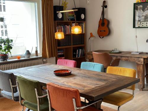 a dining room with a wooden table and chairs at 2 værelses retro lejlighed på Torvet in Horsens