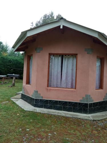 a small house with a window on the side of it at Cabañas La Perla in Golondrinas