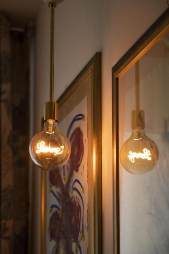 two lights hanging on a wall next to a picture at Boutique Hotel Ferrara in Ferrara