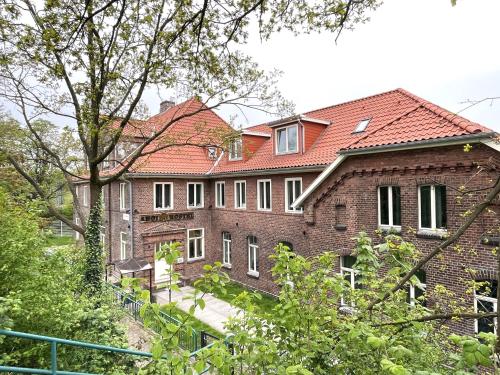 ハンブルクにあるAhoi Hostelの赤い屋根の大きなレンガ造りの家