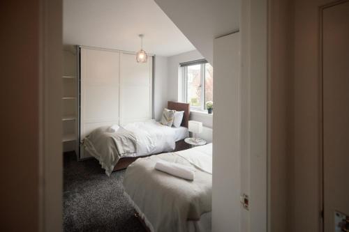 a bedroom with two beds and a window at A Stunning And Slick Escape in Stonehouse