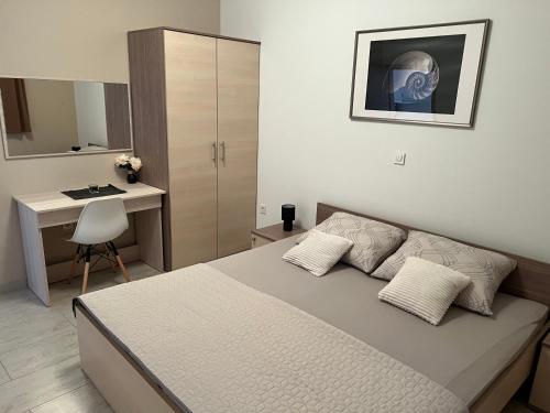 a bedroom with a bed and a desk and a table at Apartmani Nina i Niko in Ugljan