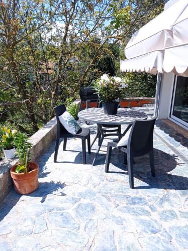 a patio with a table and chairs and an umbrella at Location Bastia, U Fiumicellu. Vue Mer. Jacuzzi, Barbecue,... Pour 2 personnes in Bastia