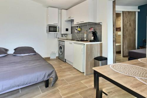 een kleine kamer met een bed en een keuken bij Bleu Lavande - Coquet appartement ambiance village in Istres