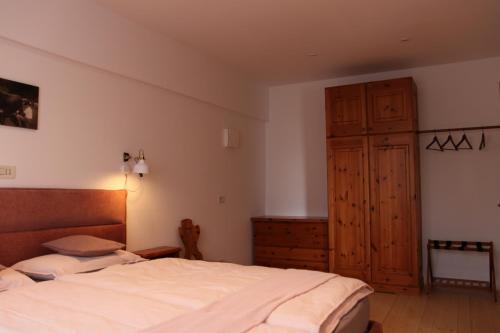 Schlafzimmer mit einem Bett und einem Holzschrank in der Unterkunft Rasterhof in Aldino