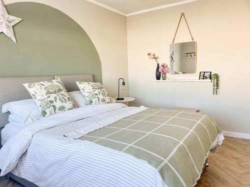 1 dormitorio con 1 cama con edredón gris y blanco en Mossdale Cottage en Dalmellington