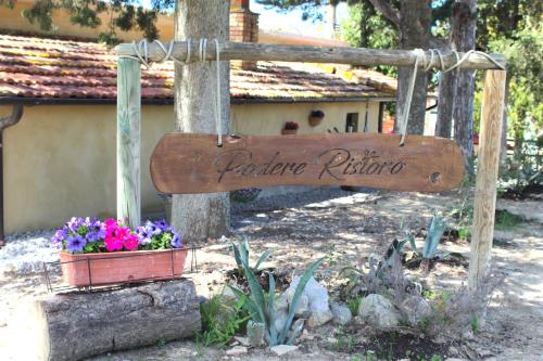 Casa vacanza Podere Ristoro في سان جيوفاني دياسو: علامة لحديقة بها زهور في القدر