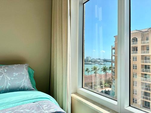 a bedroom with a window with a view of a city at Belle Harbor 803-M - Panoramic Views in Clearwater Beach