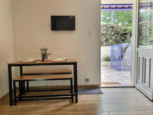 een eetkamer met een tafel met wijnglazen erop bij Bleu Lavande - Coquet appartement ambiance village in Istres