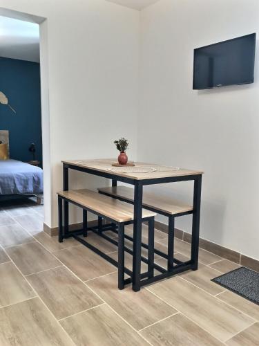 - une table et un banc dans une chambre avec une télévision dans l'établissement Bleu Lavande - Coquet appartement ambiance village, à Istres