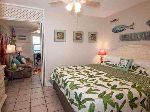 a bedroom with a bed and a living room at Chateau 6W Alluring Beachfront Condo in Clearwater Beach